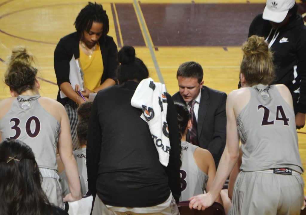 Coach Nate Vogel speaks with his team about a play in 2020