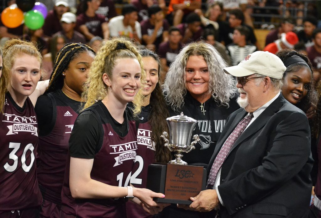 President Arenaz presents a trophy to women's basketball