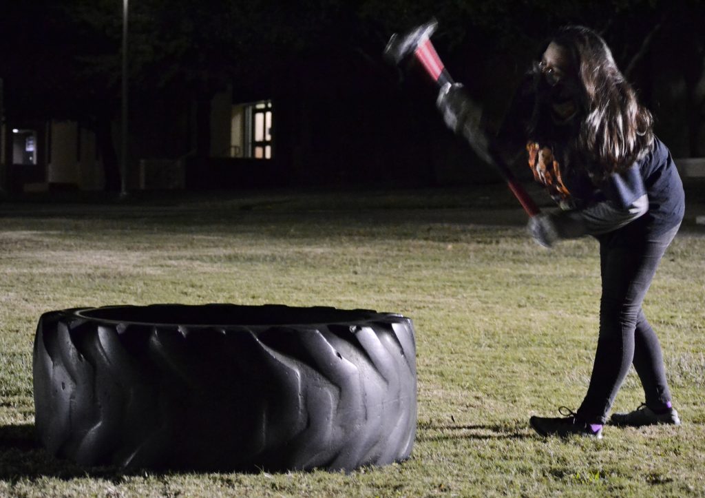 student takes a sledgehammer to a large tire