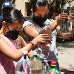 Children look at 2-liter bottles filled with water