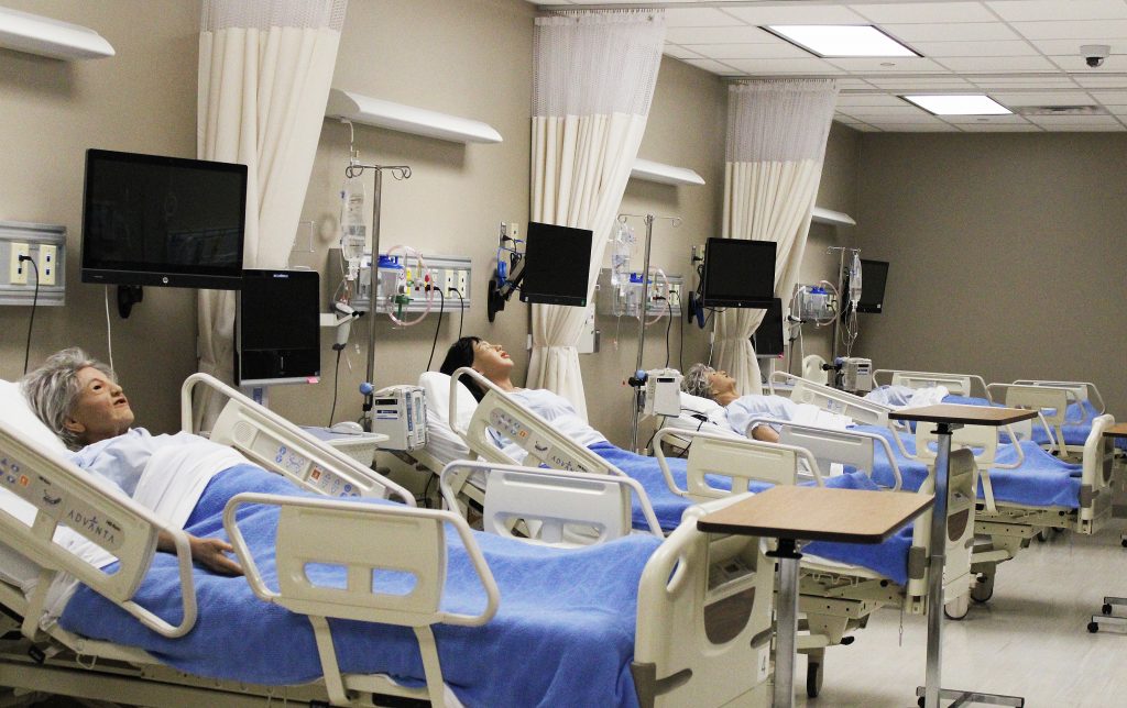 Medical mannequins line the hospital beds inside Canseco Hall