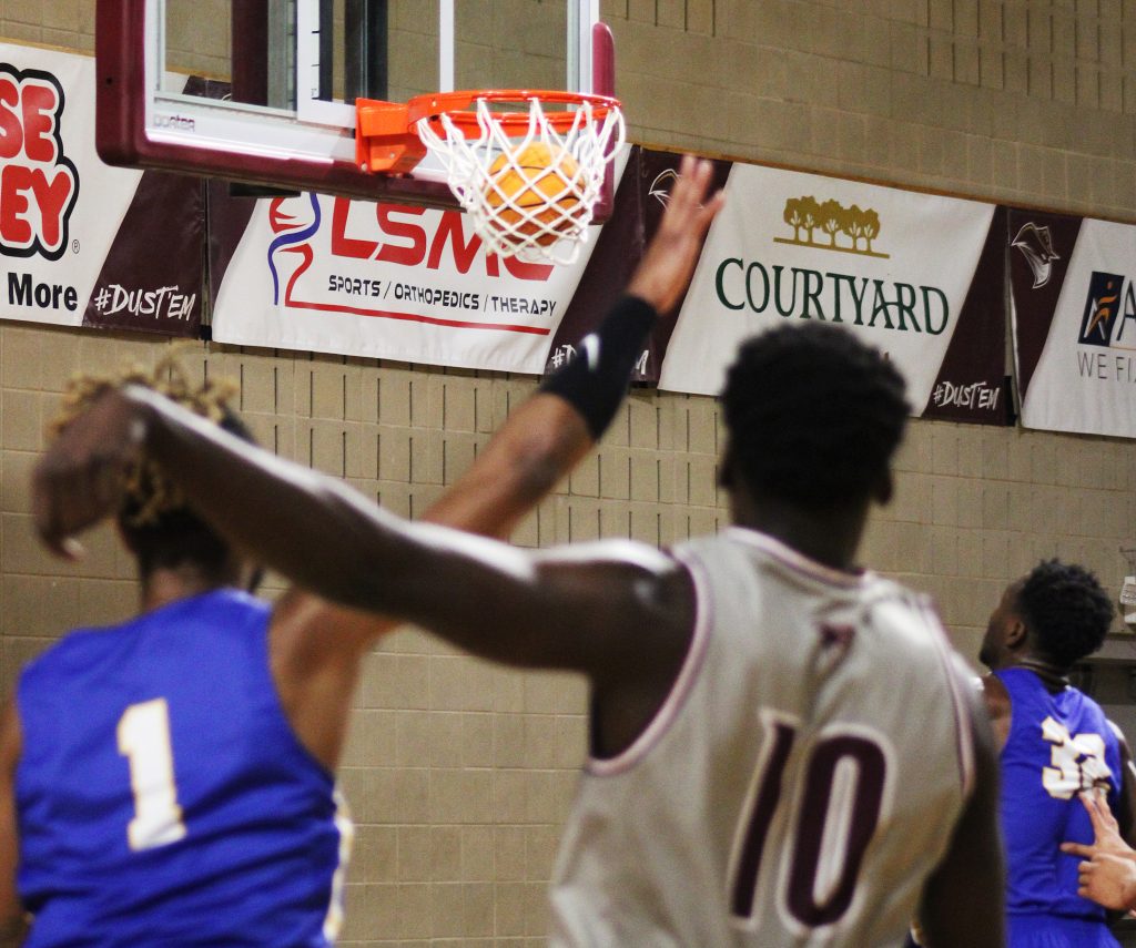 Jermaine Dewey sinks a three pointer during a basketball game.