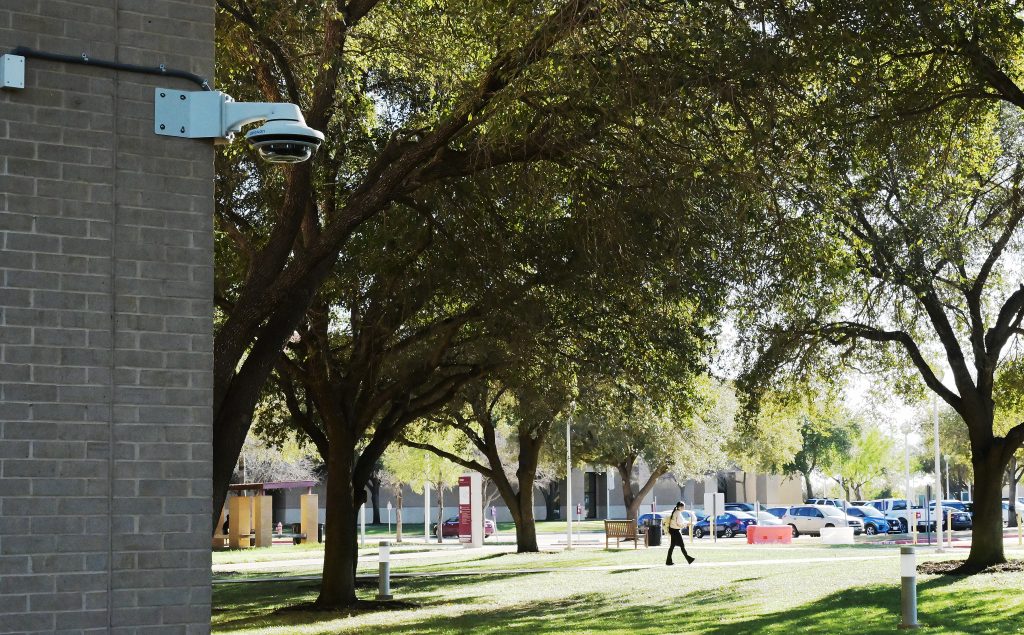 Students walk on campus under the watchful eye of security cameras