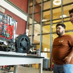 STEM students look over an electronics and mechanical project.