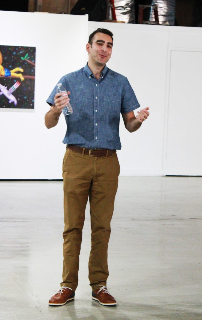 Assistant Professor of art Josias Figuerido speaks during the opening of the art exhibit.