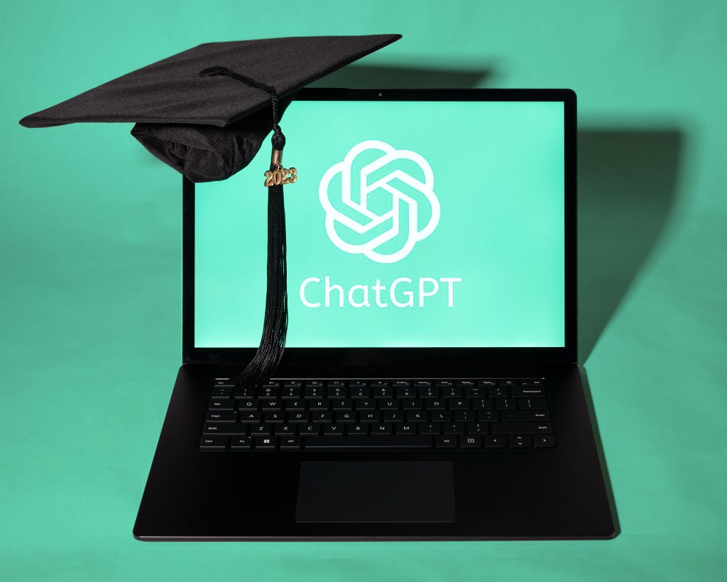 Computer with ChatGPT logo and a graduation cap.