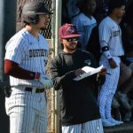 Coach works with a player on the sidelines during a game.