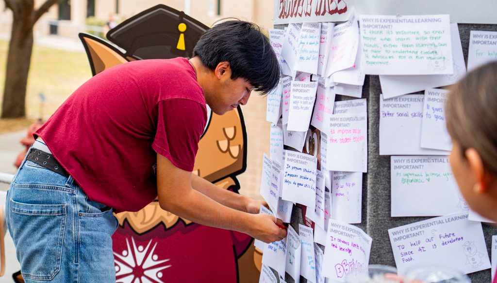 Students add papers to the Graffiti Wall.