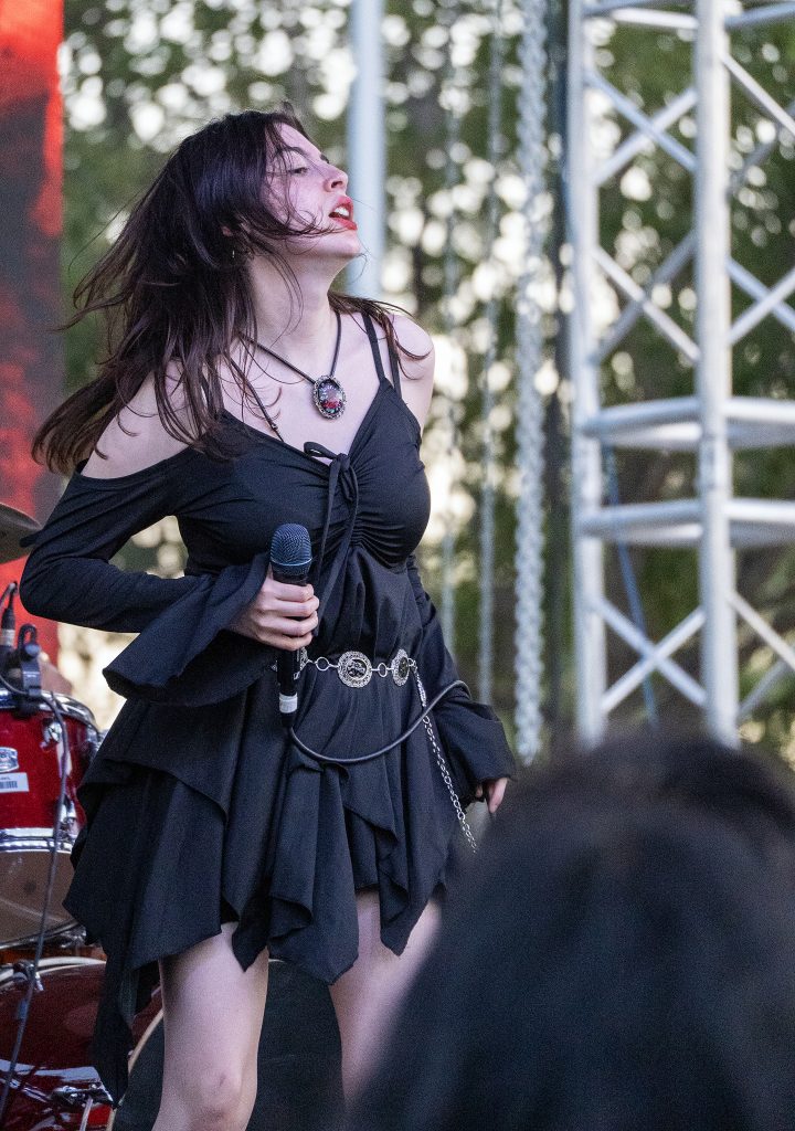 Singer performs with microphone on stage.