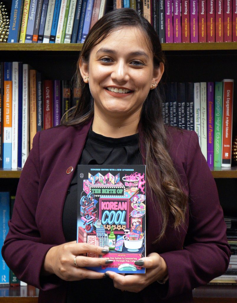 Reading the Globe adviser poses for photo with the program's book.