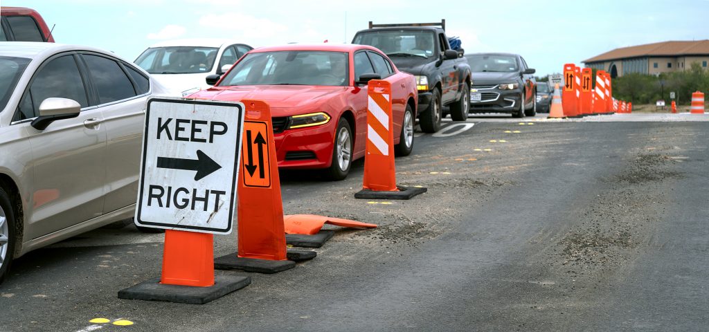 Cars wait in a long line at the main campus exit.
