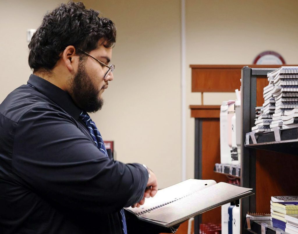 Student looks at a book at the TAMIU Bookstore.