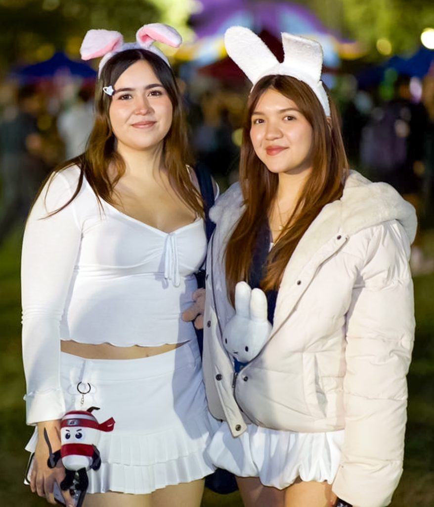Two students in costumes pose for a photo
