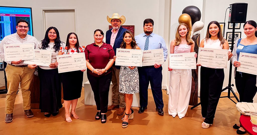 A group of students pose with their scholarship checks.