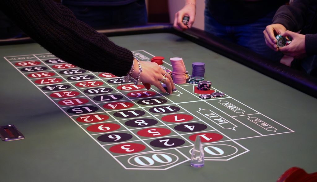 Hands place bets on a gambling table.