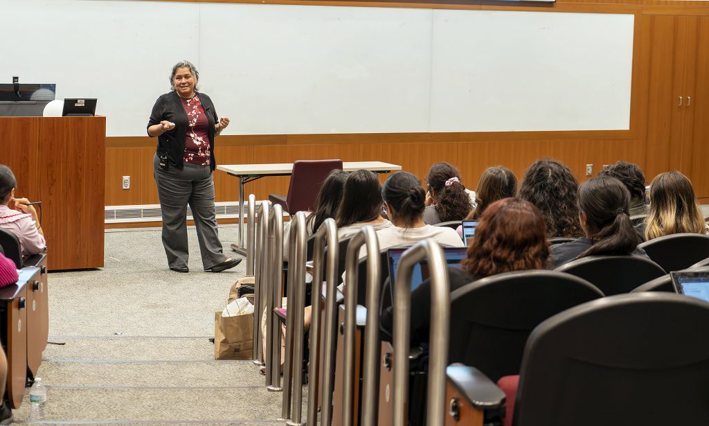 a nursing professor speaks to students from the front of a classroom