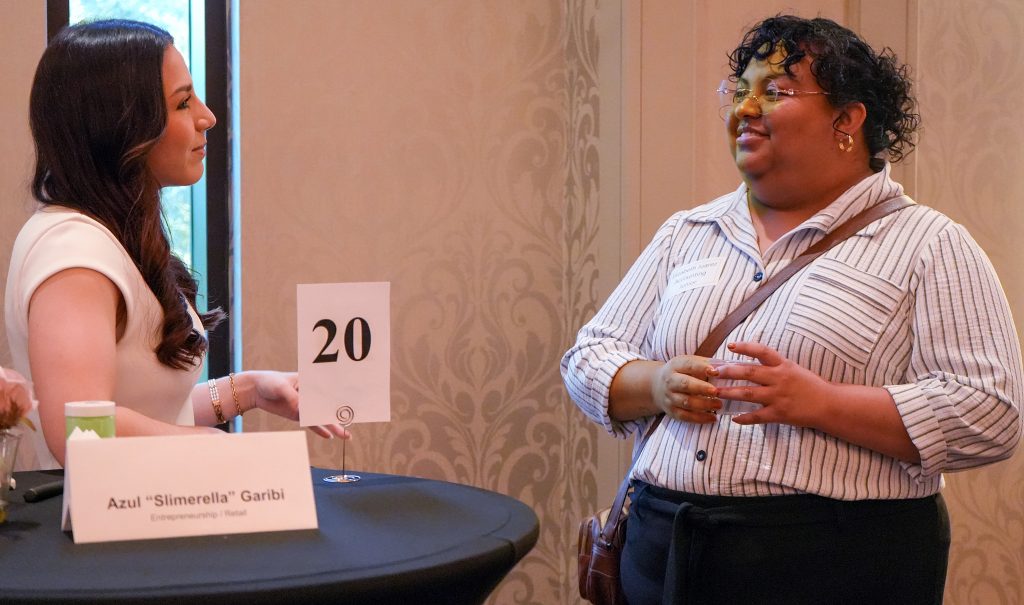 A business owner speaks to a student during a networking event.