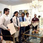 Scholarship recipients poses with their scholarship documents.