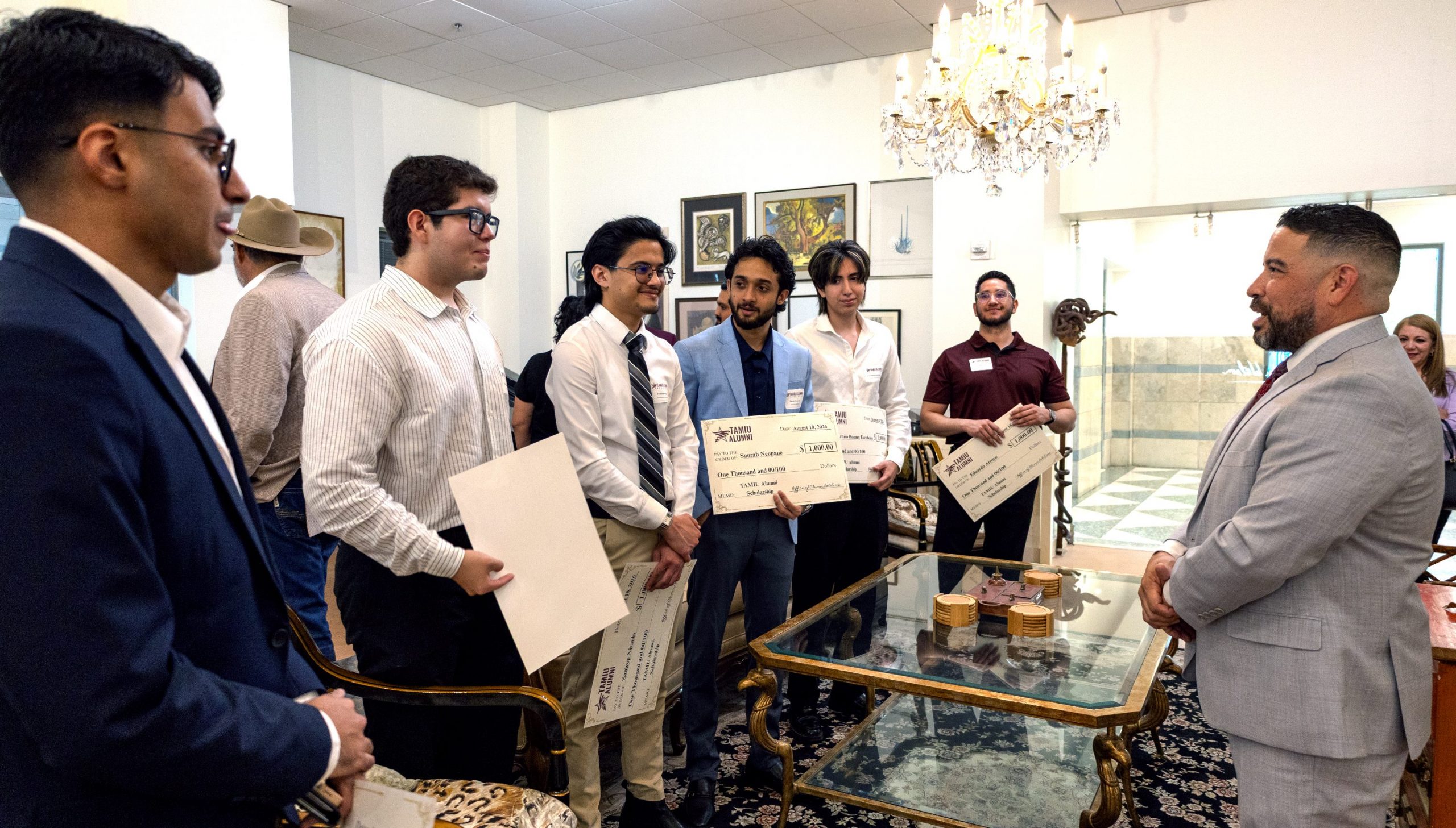 Scholarship recipients poses with their scholarship documents.