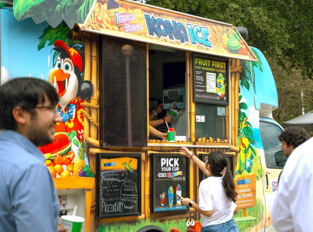 Students get snow cones from a food truck during the block party.
