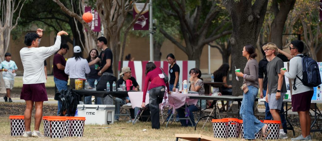 Students shoot baskets at the organization booths during the block party.