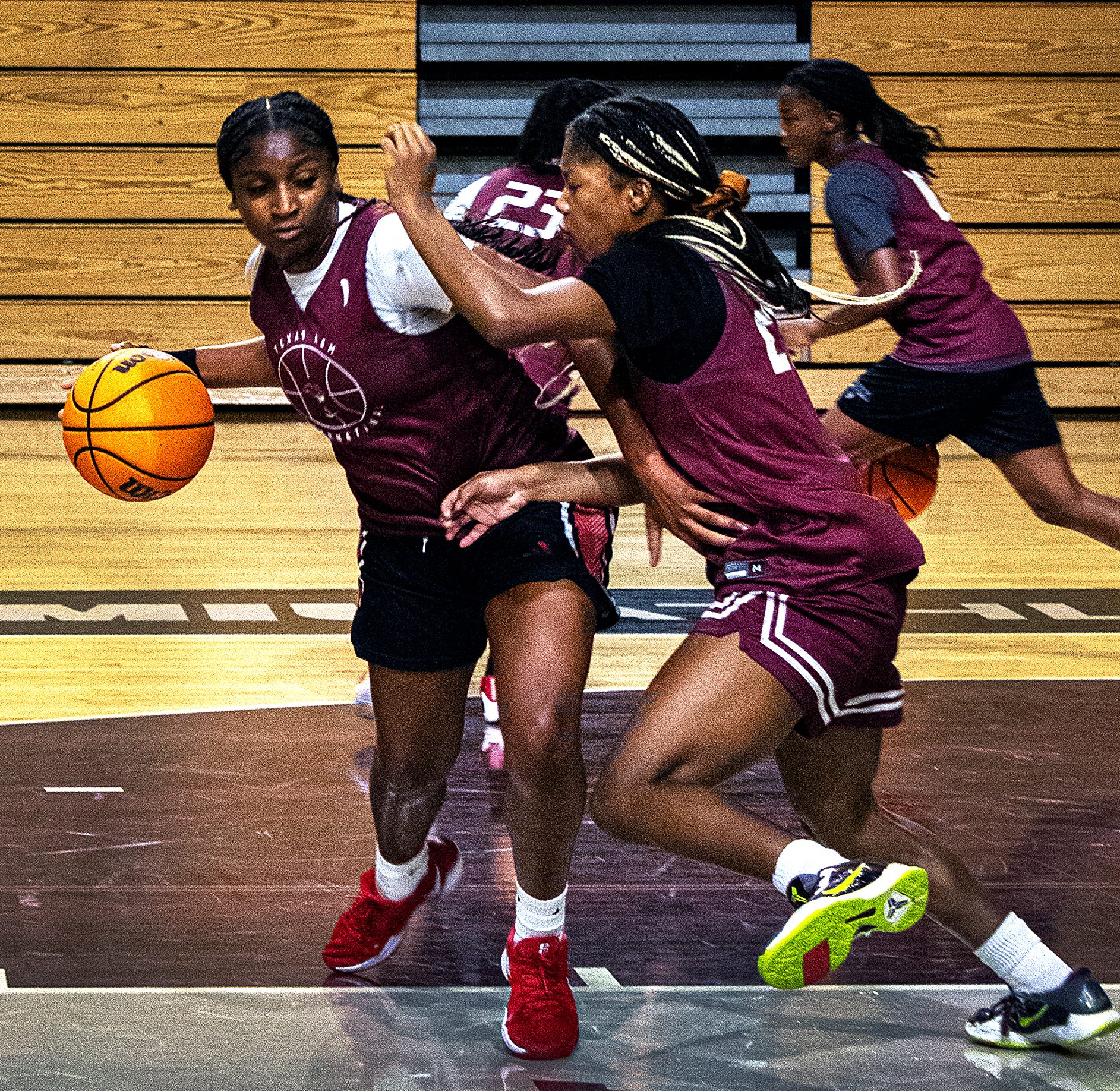 Basketball players practice in the gym.