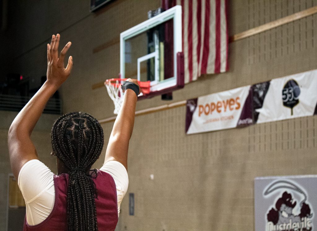 basketball player shoots toward the goal.